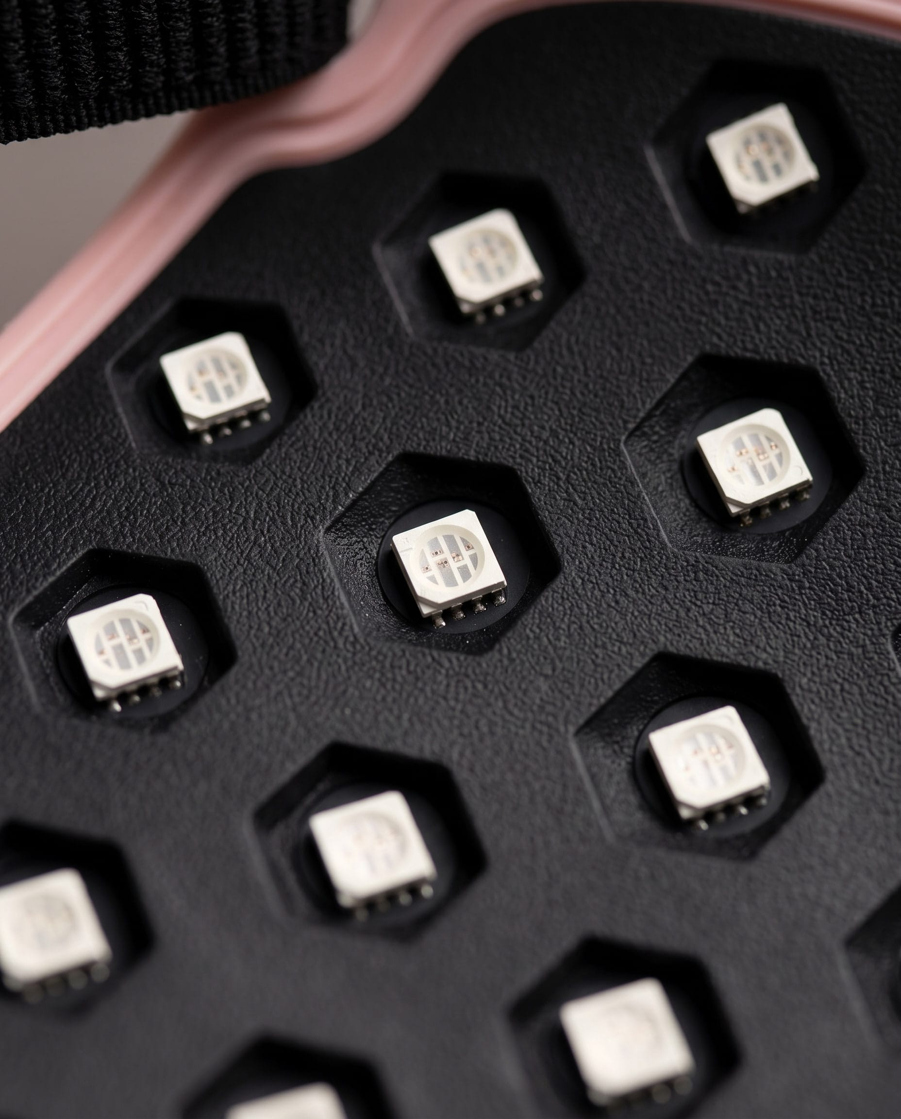 Macro of the inside of the 4D LED mask: white LED chips seated in hexagonal recesses in the black silicone panel